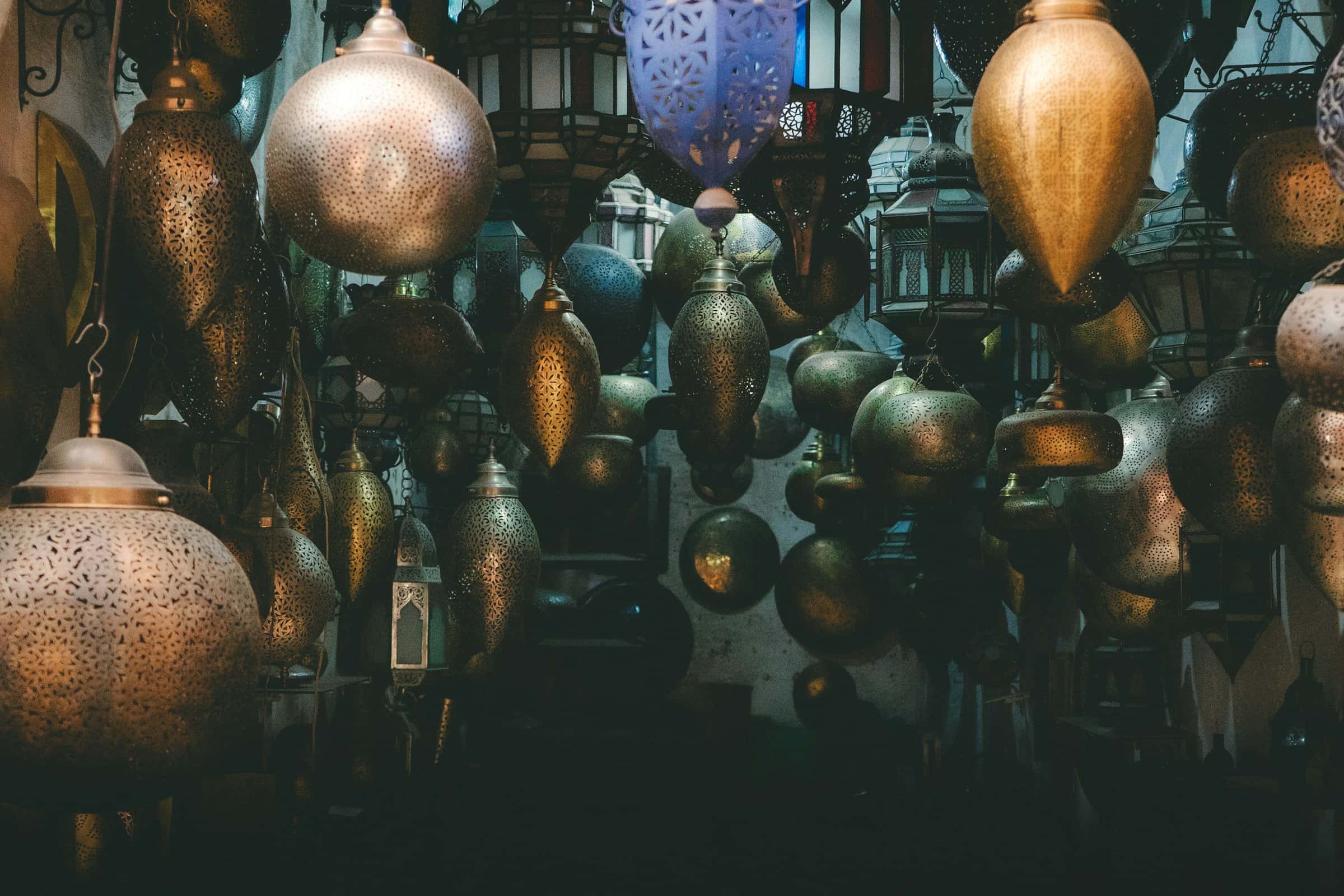 Pierced brass lanterns hanging in a dimly lit market