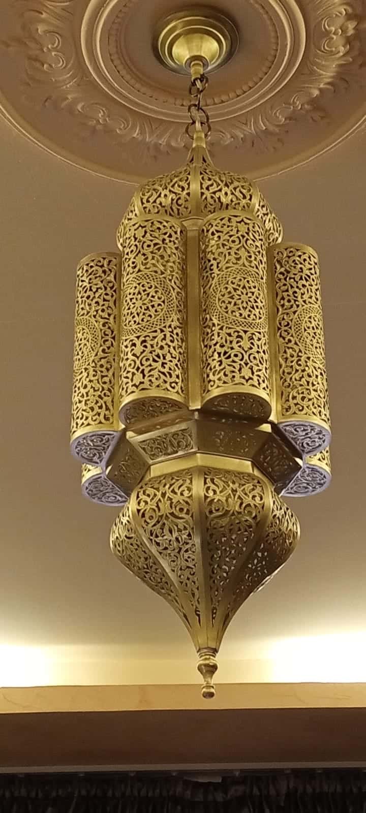 Hand-pierced Moroccan brass pendant light hanging from a ceiling rose
