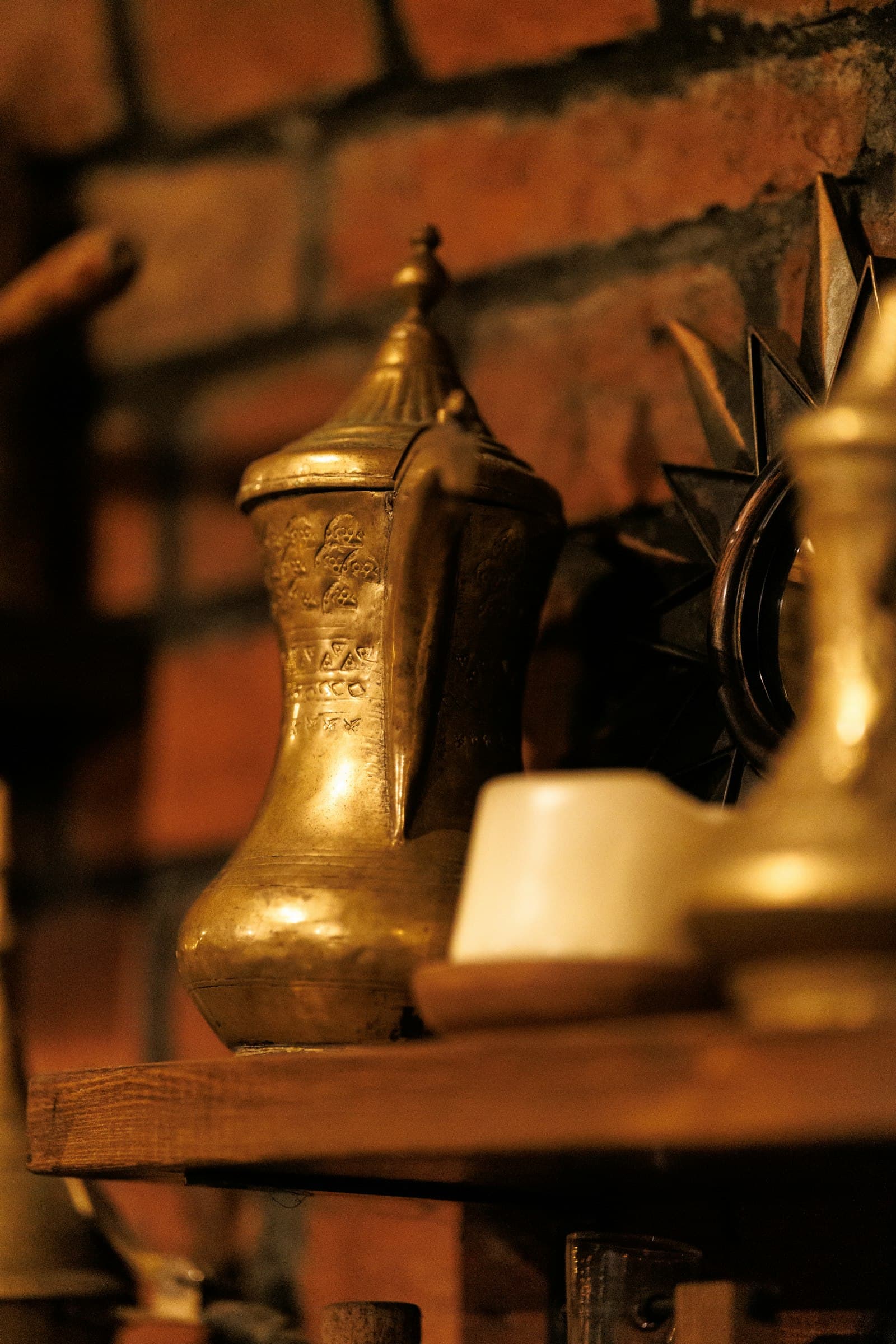 An old brass coffee pot with an engraved pattern